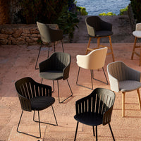 "Set of modern chairs in black, white, and beige with sleek striped patterns against a natural background."