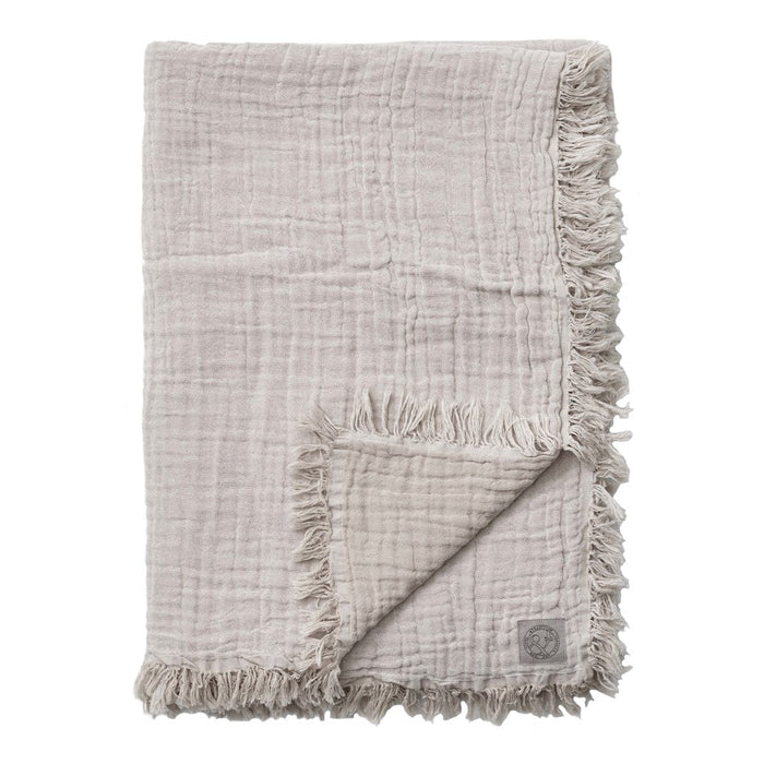 Soft beige blanket with fringed edges and a textured, crinkled pattern. Perfect for cozy home decor.