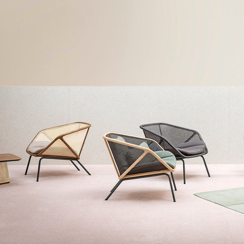 "Modern lounge chairs in mesh, featuring a beige, black, and aqua color palette against a soft pink background."