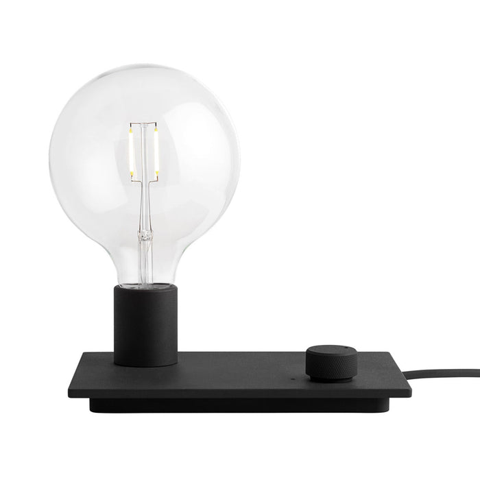Black base lamp with a clear glass bulb, featuring a minimalist design and a sleek, modern aesthetic.