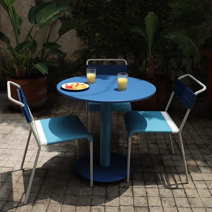 Blue round table with two matching chairs, featuring a modern design and vibrant color scheme.