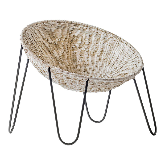 Natural woven basket with a textured beige finish and sleek black legs, ideal for modern decor.