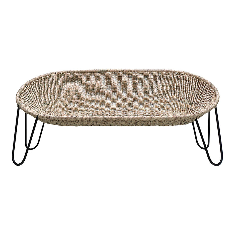 Woven natural fiber basket with a sleek black metal frame, featuring an oval shape and soft, textured pattern.
