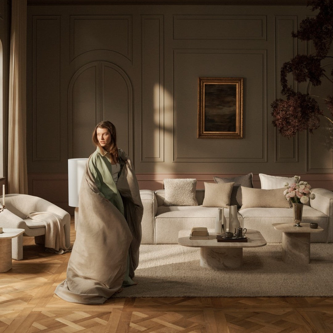 Soft beige and green throw blanket draped elegantly in a cozy living room setting, complemented by neutral-toned decor.