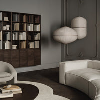 Elegant gray background with dark wooden shelving, cream furniture, and striped white lamps. Sophisticated neutral palette.