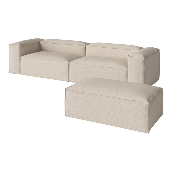 Beige modular sofa with simple, modern design and smooth texture, complemented by a matching ottoman.