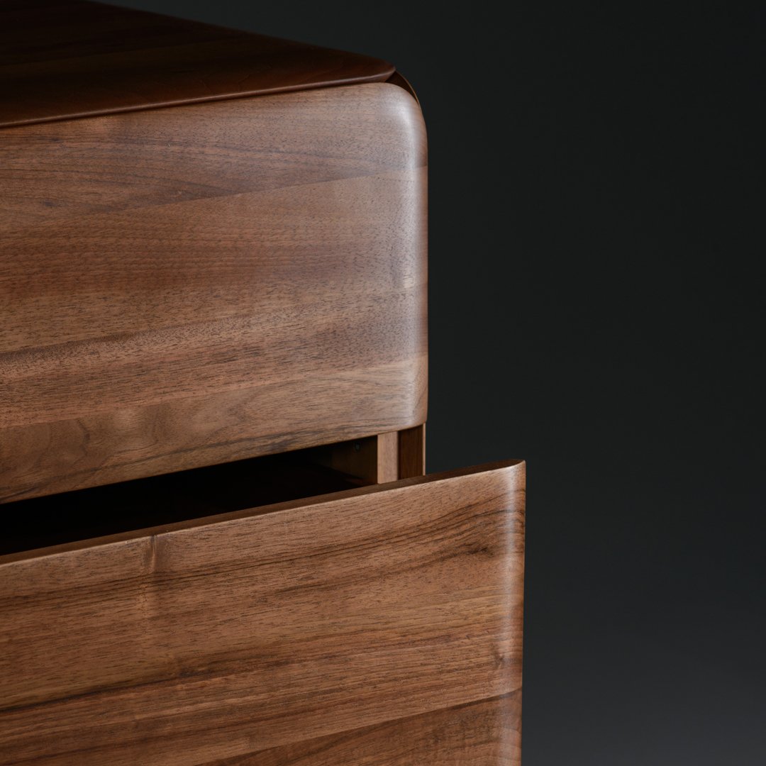 Close-up of a smooth walnut wood surface with a rich, warm brown tone and subtle natural grain patterns.