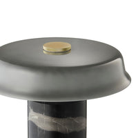 Round gray tabletop with a sleek finish, featuring a gold accent on a textured black pedestal. Modern design aesthetics.