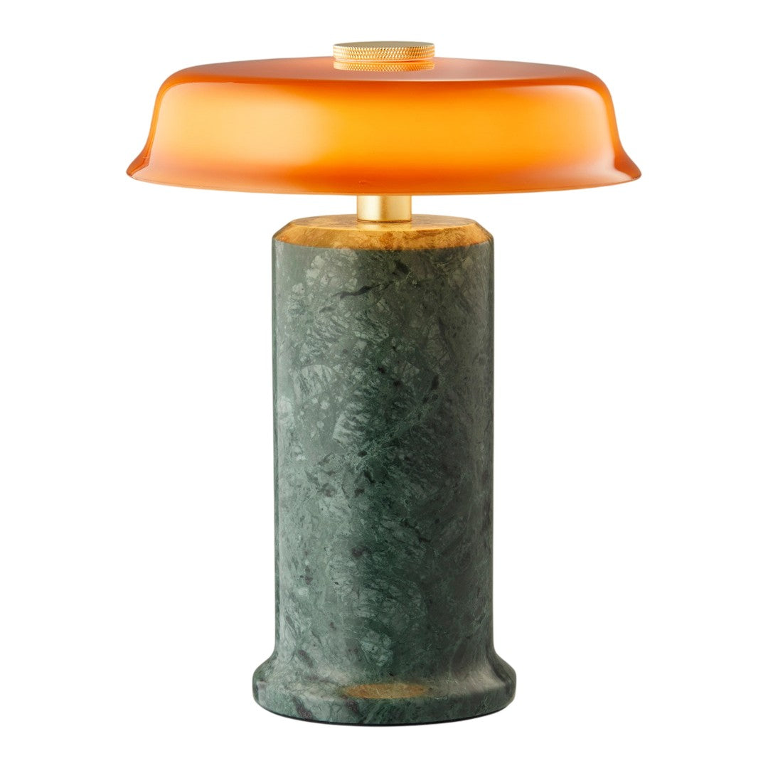 Orange glass lampshade on a green marble base, featuring smooth textures and bold color contrast.