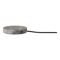 Round gray marble charging pad with a sleek, minimalist design and black cord. Ideal for modern decor.