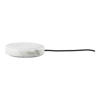 Round white marble charging pad with subtle gray veining and a sleek black cord for modern decor.