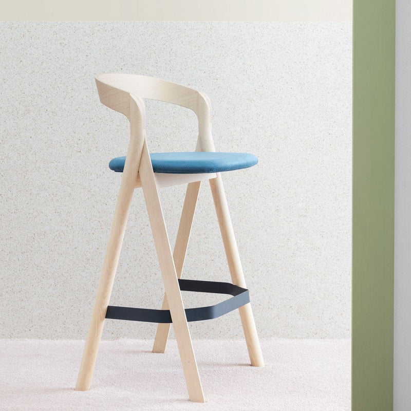 Light wood bar stool with a blue seat and dark blue footrest against a neutral textured background.