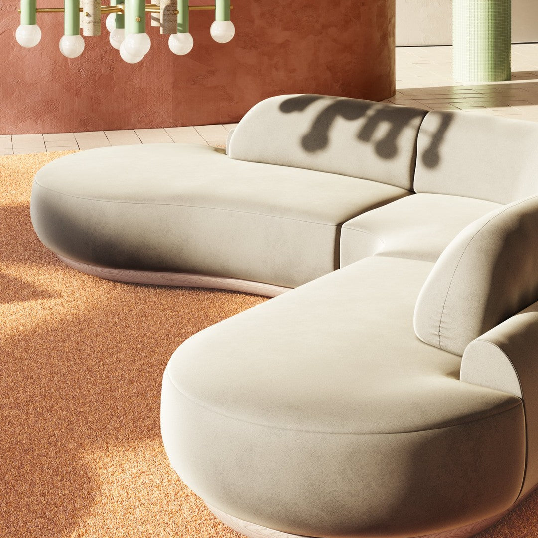 Curved beige sofa on textured orange rug, featuring soft lines and a minimalist design for modern interiors.