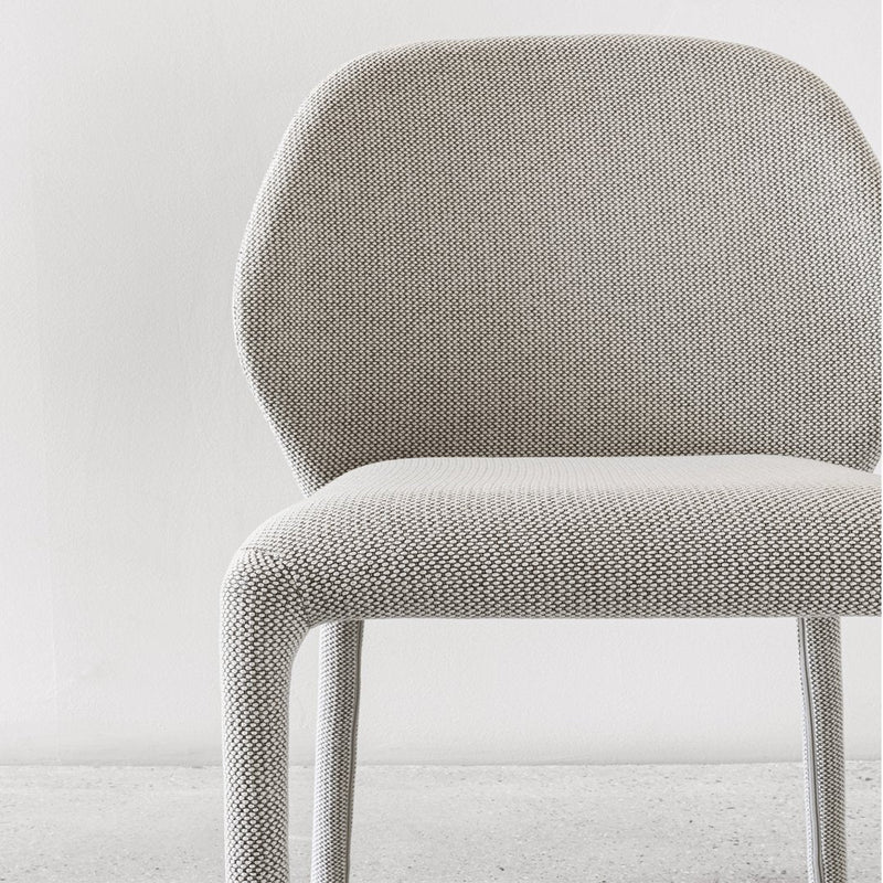 Light gray textured chair with a modern pattern and soft, rounded edges, perfect for contemporary decor.