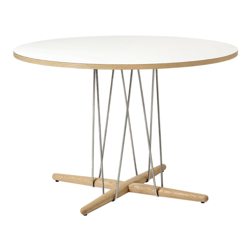 Round white tabletop with natural wood base and sleek silver supports, creating a modern minimalist design.
