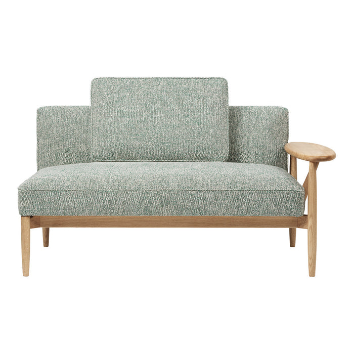 Green patterned loveseat with natural wood armrest, perfect for modern interiors. Soft, textured fabric design.