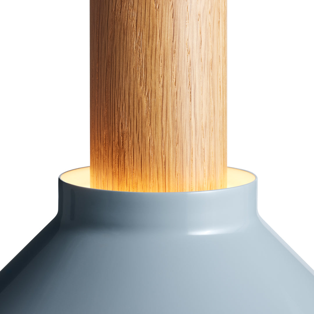 Light gray lamp base with a natural wood pole, featuring a smooth finish and warm glowing light pattern.