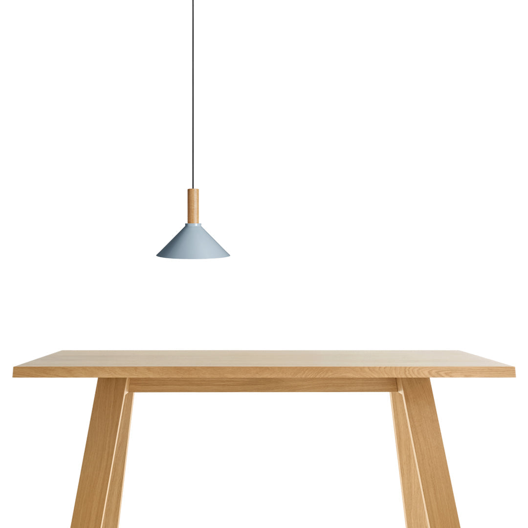 Sleek blue pendant light with natural wood accents above a simple wooden table, showcasing a minimalist design.