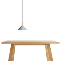 Sleek blue pendant light with natural wood accents above a simple wooden table, showcasing a minimalist design.