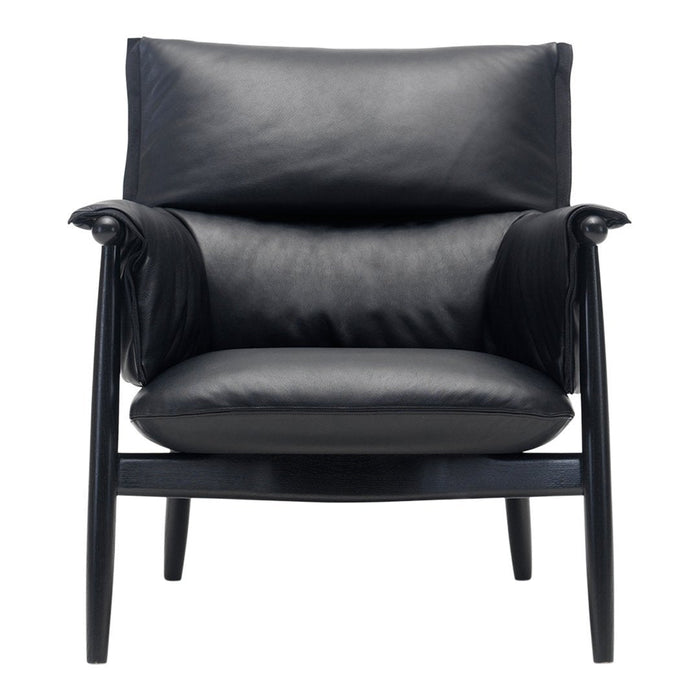 Black leather armchair with smooth cushions and sleek black wooden legs, exuding modern elegance and comfort.