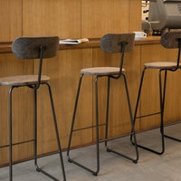 Stylish bar stools featuring a black metal frame and textured gray seat with a minimalist design, perfect for modern decor.