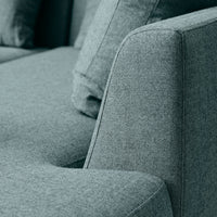Textured gray fabric sofa with soft angles and coordinating throw pillows in a modern design.