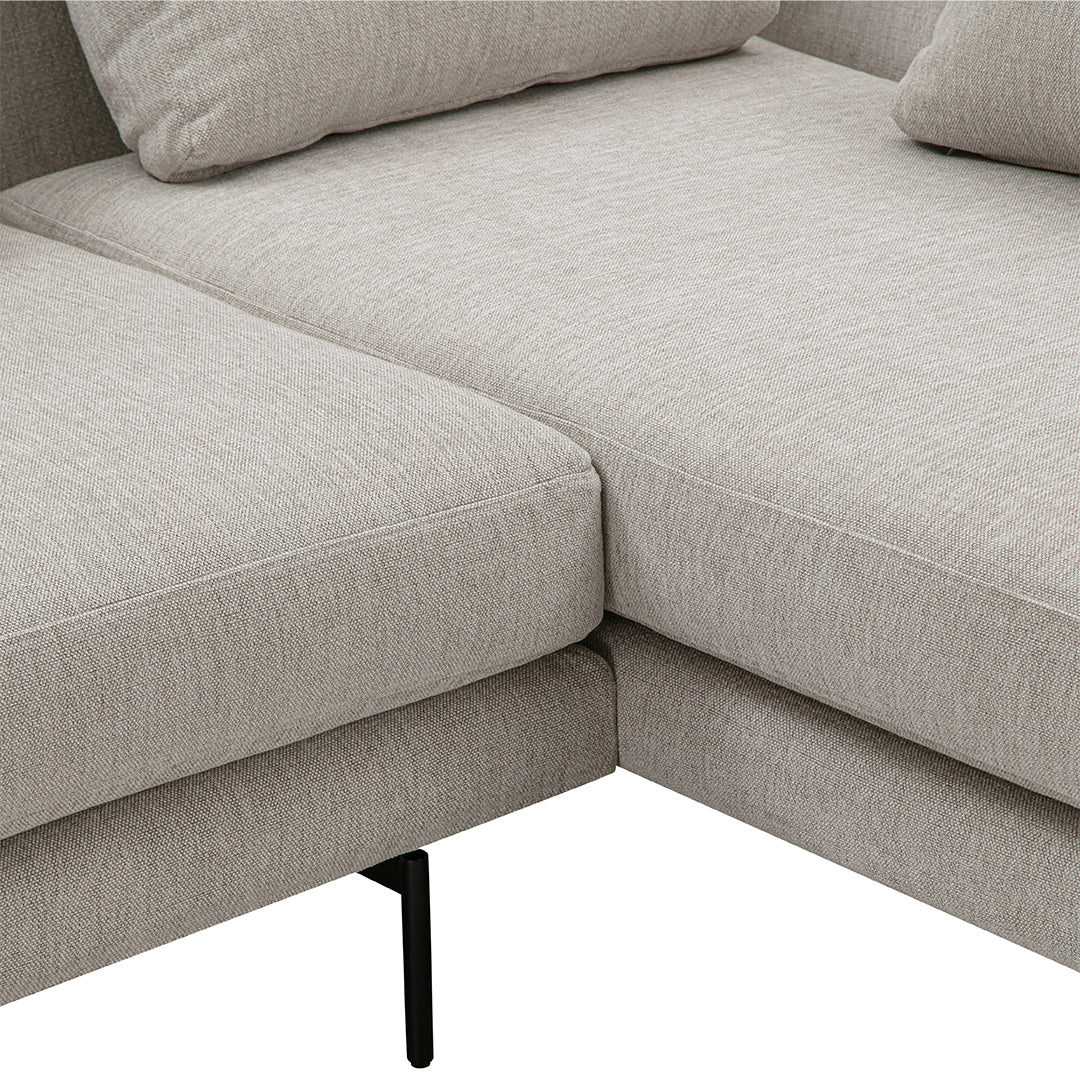 Light beige sectional sofa with a subtle texture, featuring minimalist design and black metal legs.