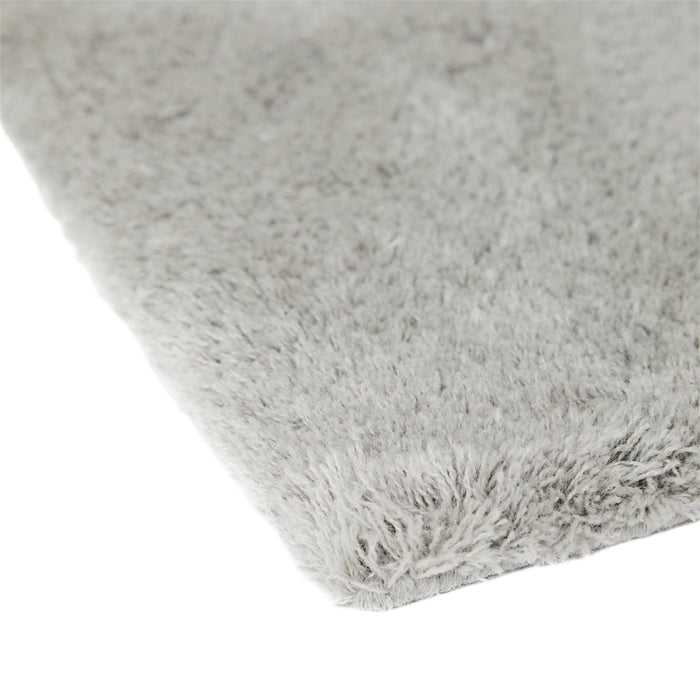 Soft gray shag rug with a plush texture, featuring subtle variations in tone and a smooth, fluffy surface.