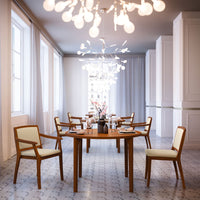Elegant wooden dining table setup with beige chairs and geometric patterned flooring, featuring a modern chandelier.