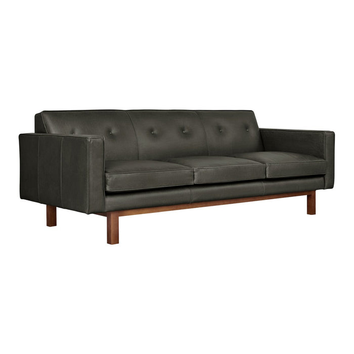 Dark gray leather sofa with a smooth texture and button details, complemented by a warm wooden base.