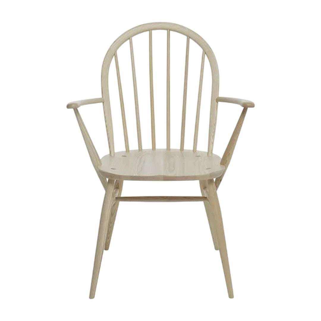 "Light natural wood armchair with a minimalist design and simple vertical slat back."