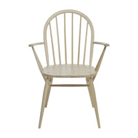 "Light natural wood armchair with a minimalist design and simple vertical slat back."