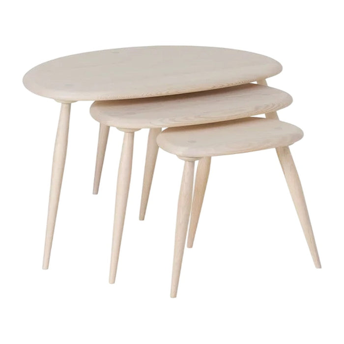 Light natural wood nesting tables with smooth, rounded tops and slender tapered legs, showcasing minimalist design.