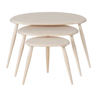 Set of three light wood nesting tables with smooth, round tops and tapered legs. Clean, minimalist design.