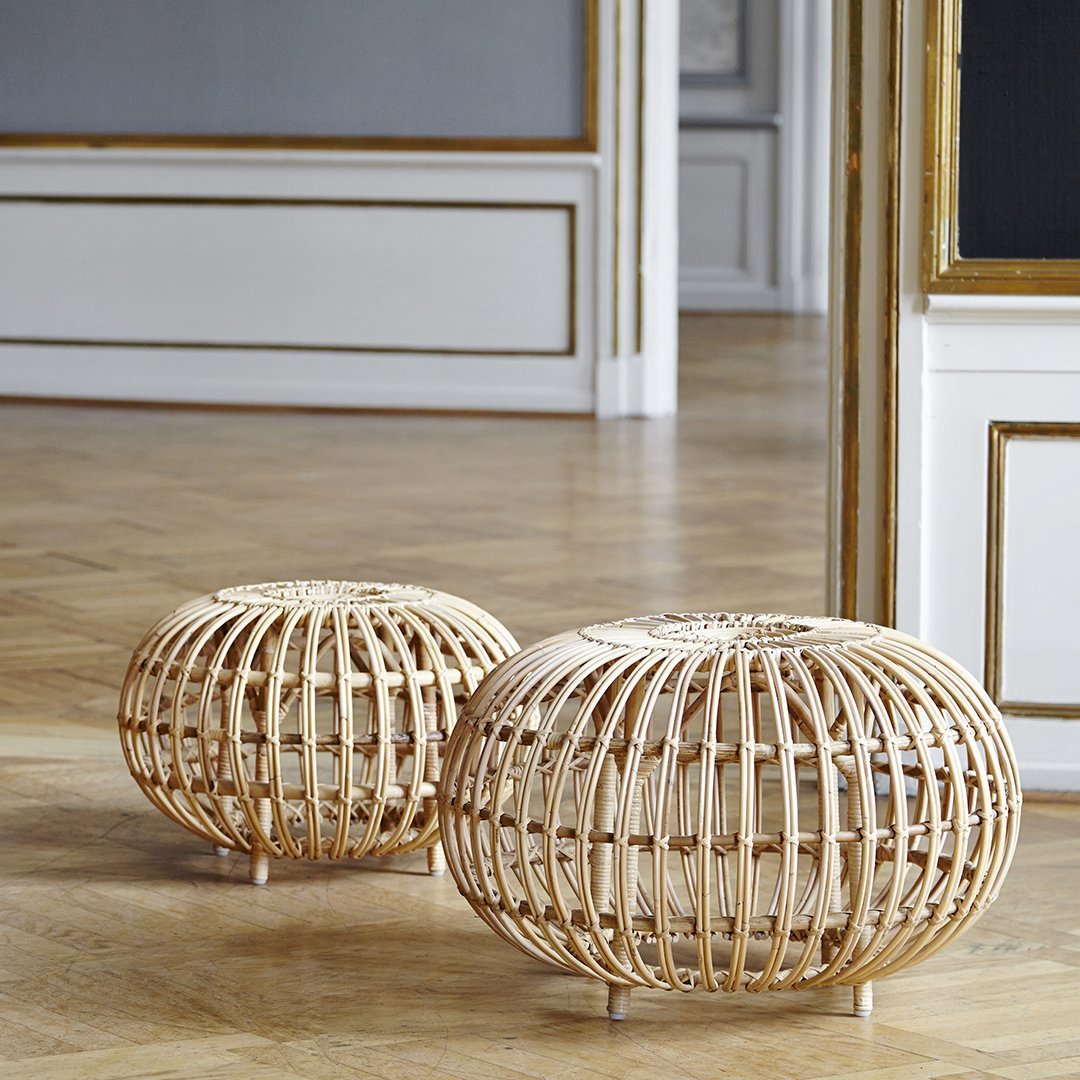 Natural rattan poufs with a circular design, showcasing a light tan color and intricate woven pattern.