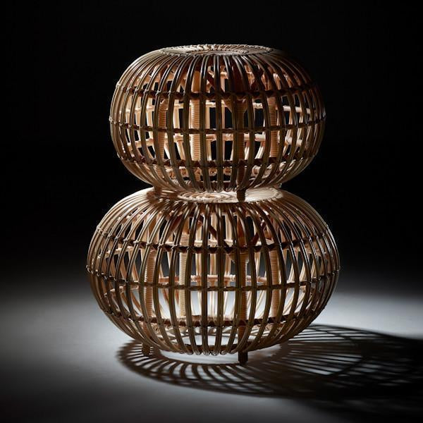 "Natural rattan woven basket in light brown with intricate lattice pattern and unique round shape."