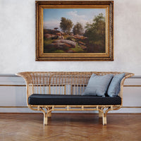 Natural rattan sofa with a black cushion and soft blue accents, set against a light wall and wooden floor.