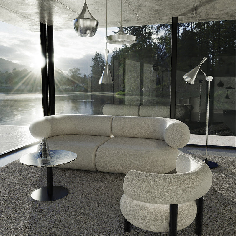 White curved sofa with textured fabric, accompanied by a matching chair, set in a modern, minimalistic interior.