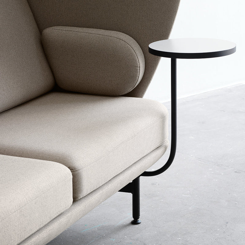 Beige upholstered sofa with a modern design, featuring a sleek black metal side table.
