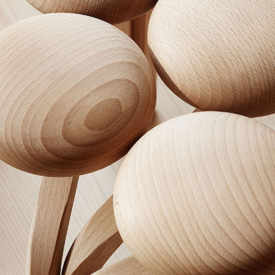 Natural wood spoons with light beige tones and subtle circular grains, showcasing their elegant, minimalist design.