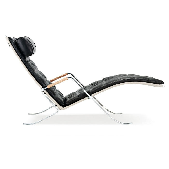 Black leather chaise lounge with sleek silver metal frame and wooden armrests, featuring smooth, curved lines.