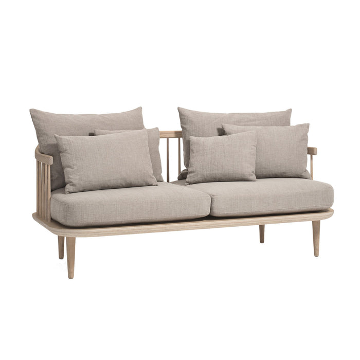 Beige plush sofa with multiple pillows and a light wood frame, featuring a simple, clean design.