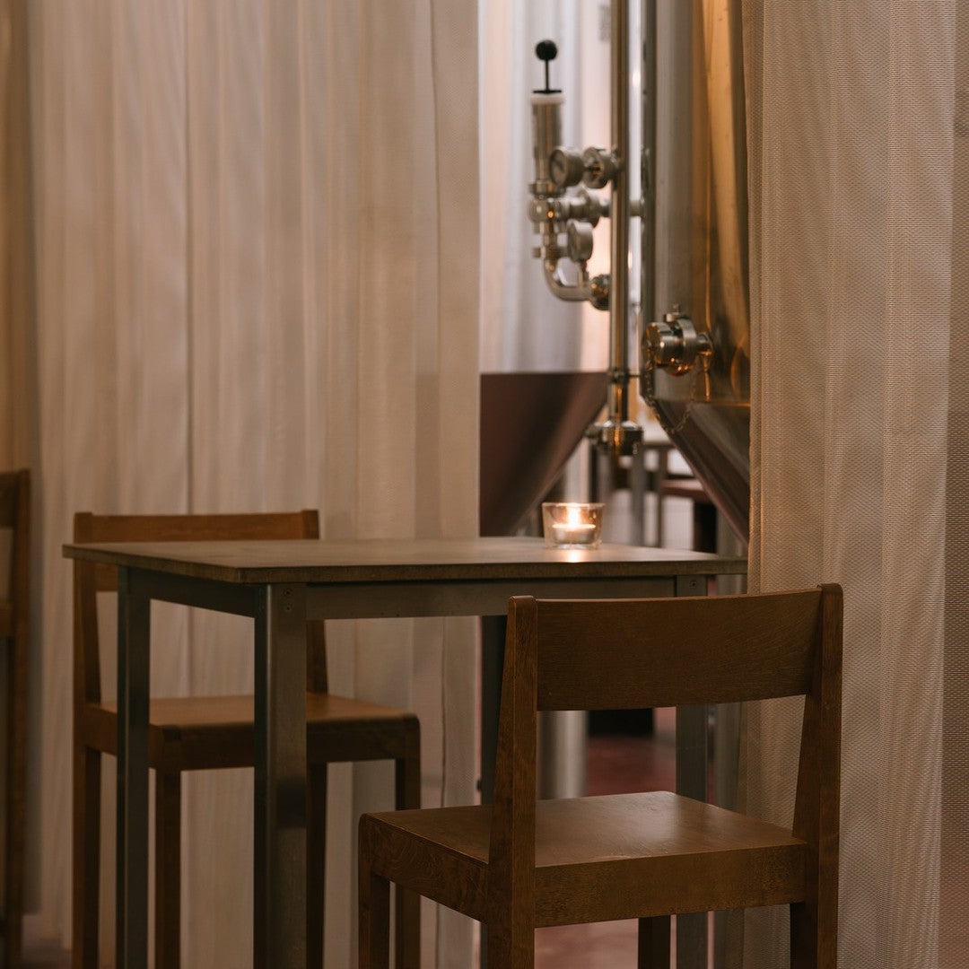 Warm wooden tones with a soft, textured curtain backdrop in a cozy dining setting.