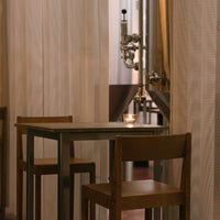 Warm wooden tones with a soft, textured curtain backdrop in a cozy dining setting.