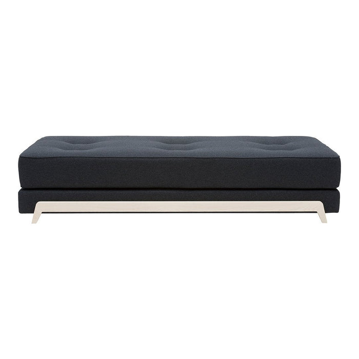 Dark navy upholstered sofa with tufted cushions and a sleek light-colored metal base, offering a modern design.
