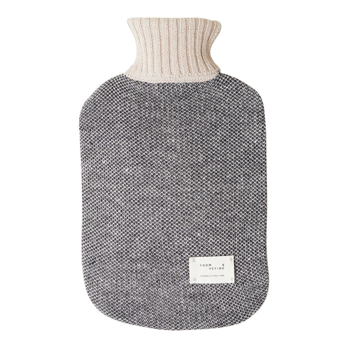 Gray textured hot water bottle cover with cream knitted neck. Stylish and cozy design for warmth and comfort.