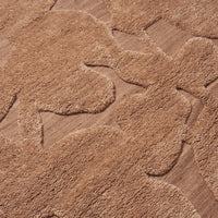 Textured beige rug featuring soft, abstract floral patterns in varying shades of tan for stylish decor.