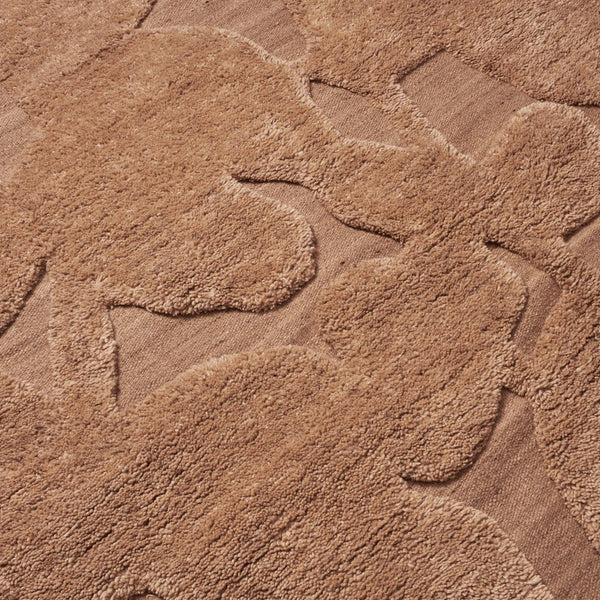 Textured beige rug featuring soft, abstract floral patterns in varying shades of tan for stylish decor.
