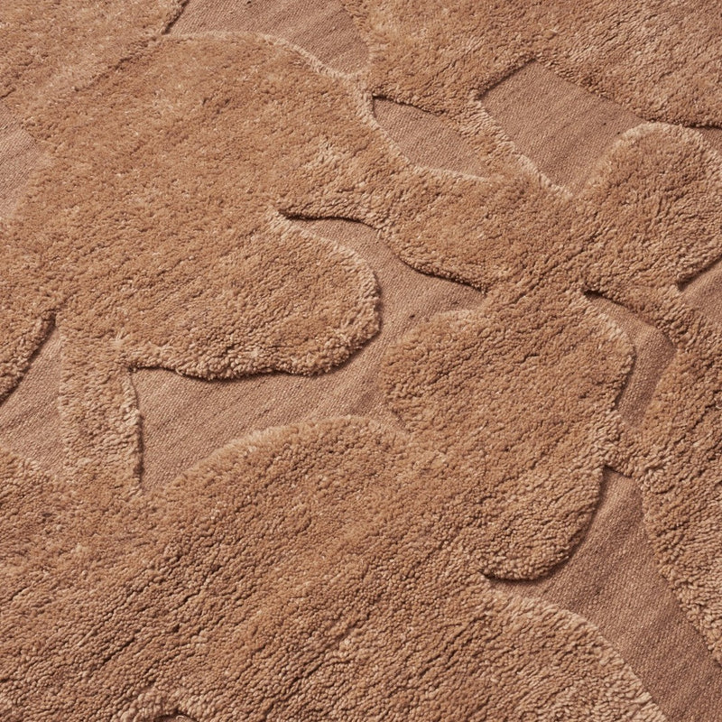 Textured beige rug featuring soft, abstract floral patterns in varying shades of tan for stylish decor.