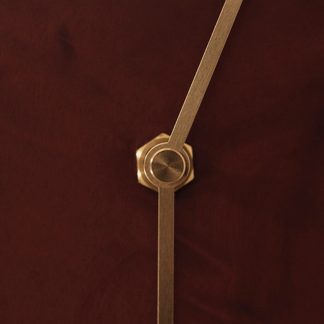 Gold hardware on a rich burgundy background with a smooth, textured finish. Elegant and modern design details.